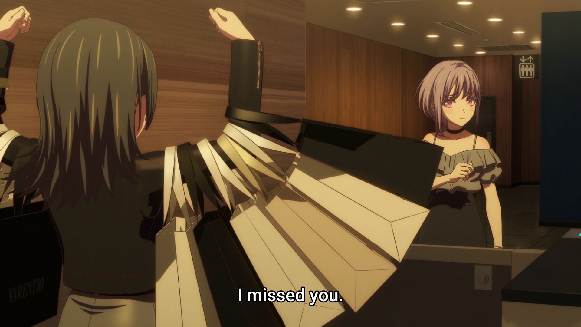 Umiri holding up shoulder bags with her biceps as Nyamu looks on